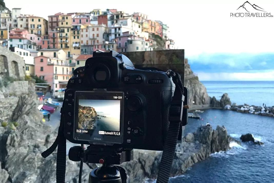 Uma Nikon D810 em um tripé diante da cidade costeira italiana de Manarola à noite, equipada com um filtro de densidade neutra e um filtro de graduação