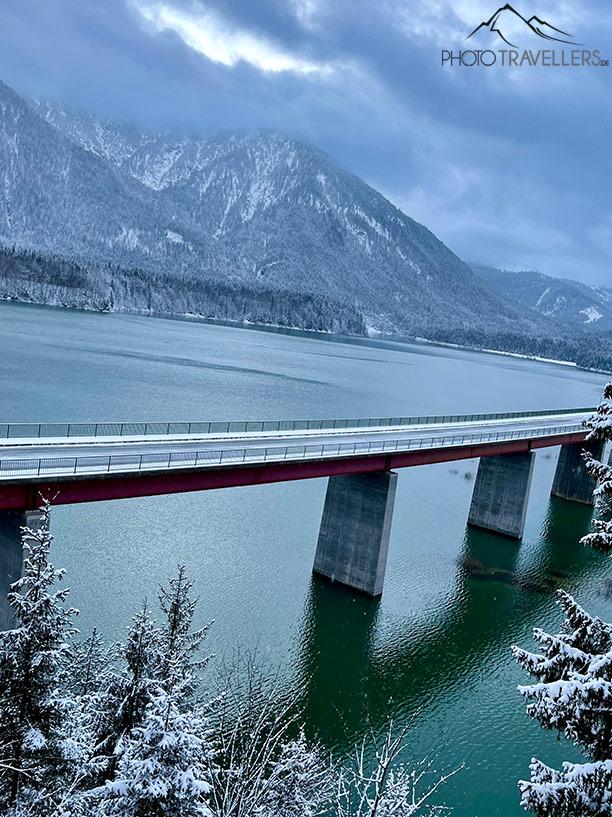 Uma ponte sobre um lago de montanha nos Alpes com um horizonte torto