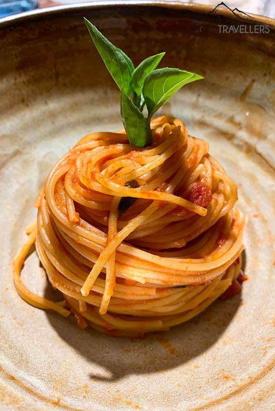 Espaguetis enrollados con salsa de tomate en un elegante plato
