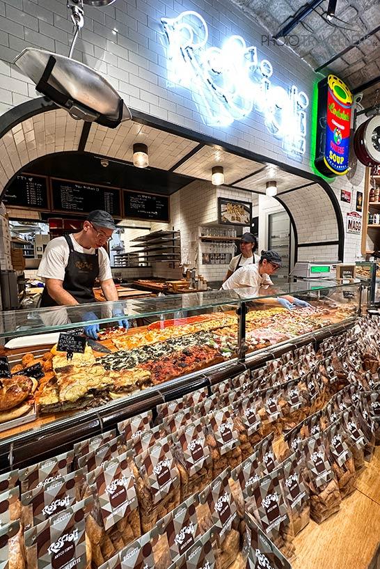 Padeiro atrás do balcão recheado no Antico Forno Roscioli em Roma