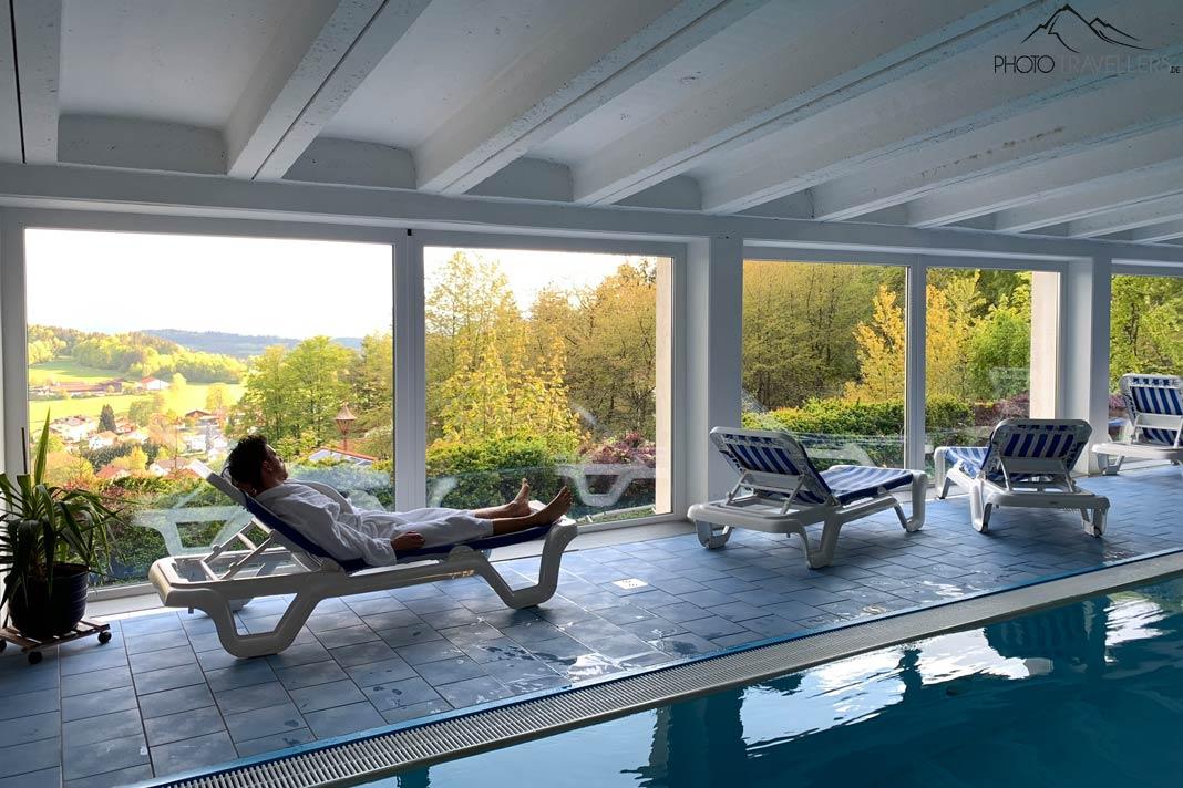 O jornalista de viagem Florian Westermann está deitado na piscina interna do Landhotel Tannenhof na Floresta da Baviera, olhando para fora
