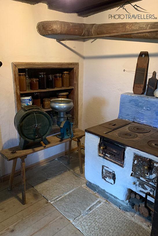 Uma cozinha com um antigo fogão na casa rural do Museu ao Ar Livre Finsterau