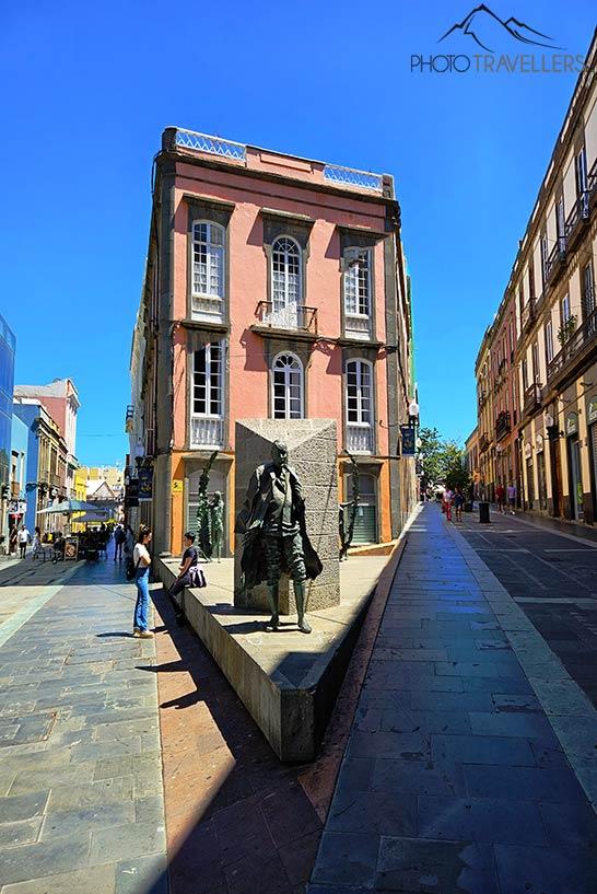 La escultura de un pez se encuentra frente a una casa de color rosa en el casco antiguo de Las Palmas 