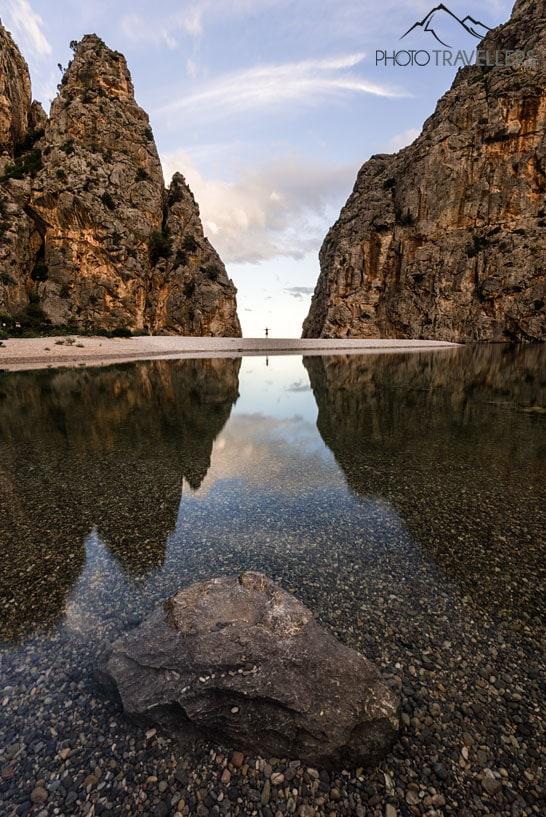 A blogueira de viagem Biggi Bauer posa na praia de Sa Calobra, mas é pequeno entre as paredes de pedra