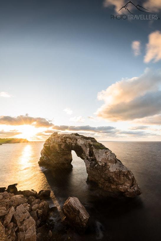 Por trás do arco rochoso Es Pontàs no mar, o sol nasce