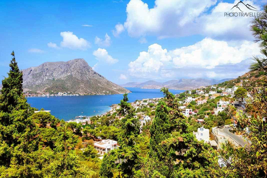 Na vila de Myrties existem muitos pinheiros, e ao fundo a ilha rochosa Telendos
