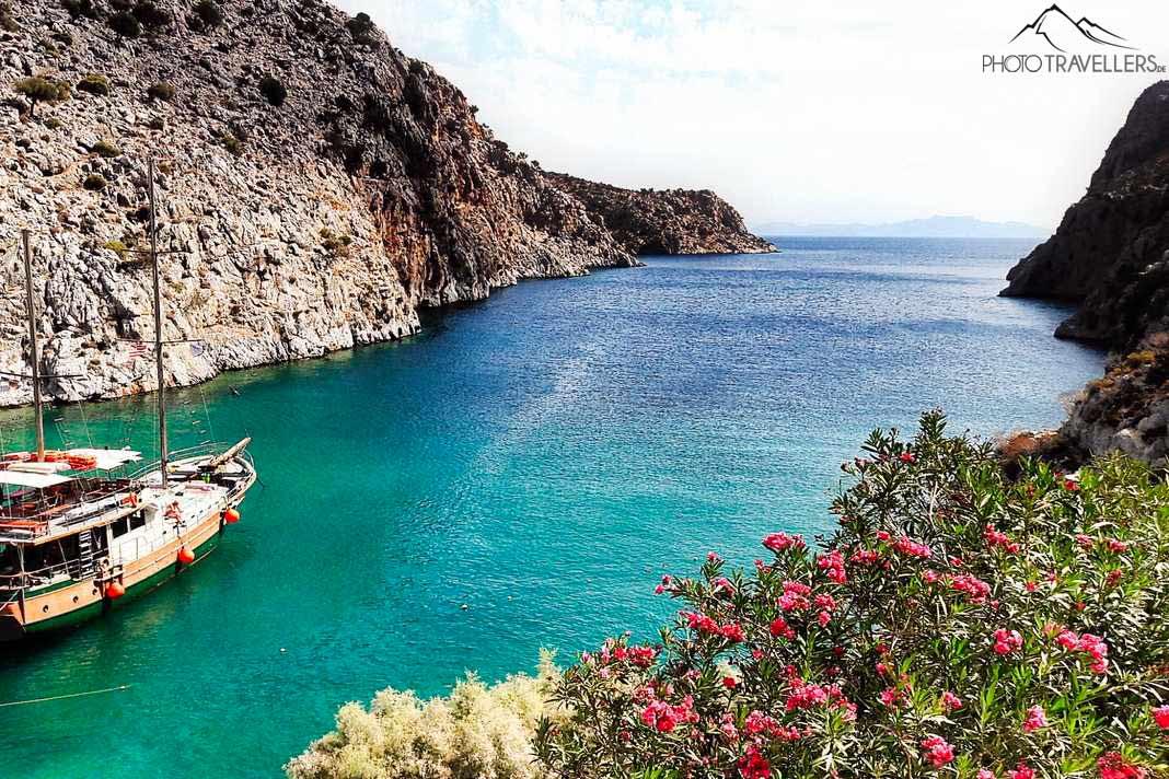 Um barco de passeio ancorado na baía turquesa de Vathy