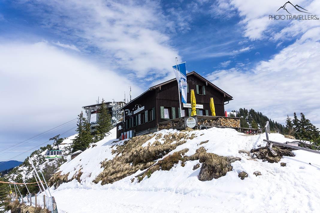 La maison Tegelberghaus dans la neige, avec le téléphérique Tegelberg derrière
