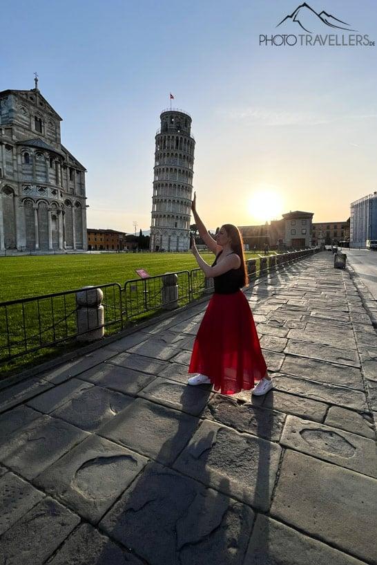 La bloguera de viajes Biggi Bauer intentando erguir la Torre Inclinada de Pisa