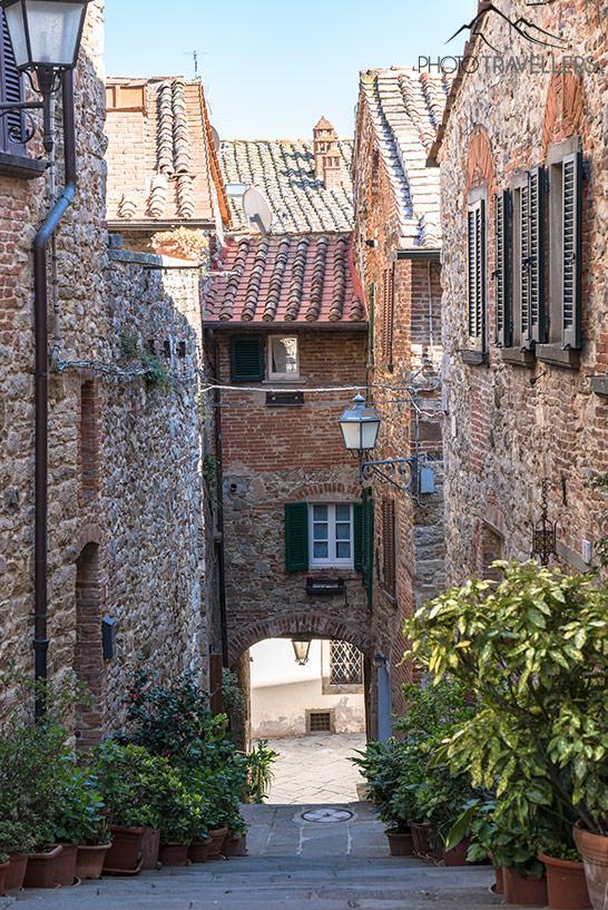 Una calle con un arco en el casco antiguo de Lucignano