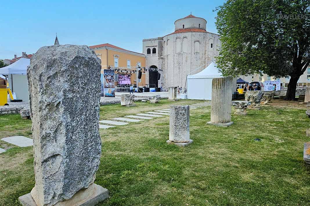 Les stèles de pierre sont alignées sur le gazon devant l'église Saint-Donat