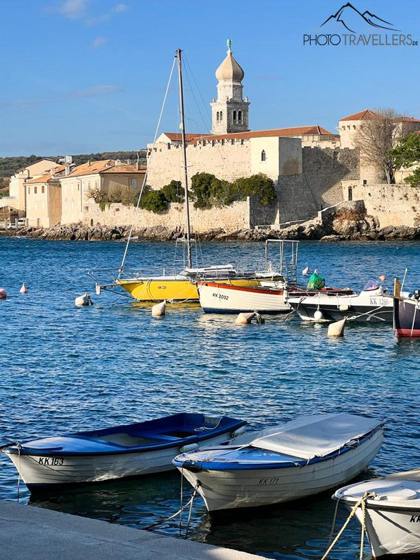 Vue sur le port et les murs de la ville avec tour à Krk