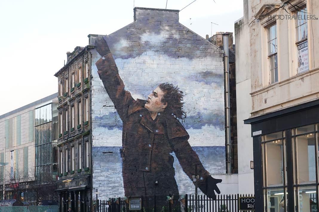 Un grand graffiti d'un homme sur un mur à Glasgow
