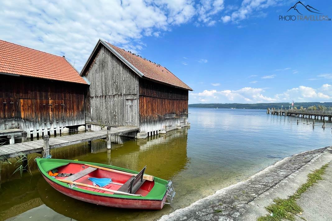 Um barco colorido e uma casa de barco em Dießen no Lago Ammersee