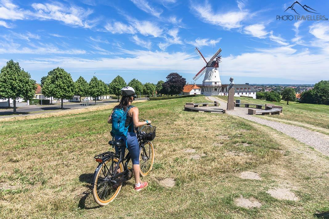 La blogueuse voyage Biggi Bauer à vélo devant un moulin à vent au Danemark