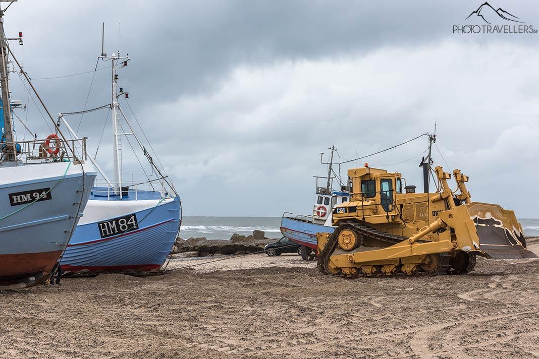 Un bulldozer tire un bateau de pêche sur la plage à Thorup Strand