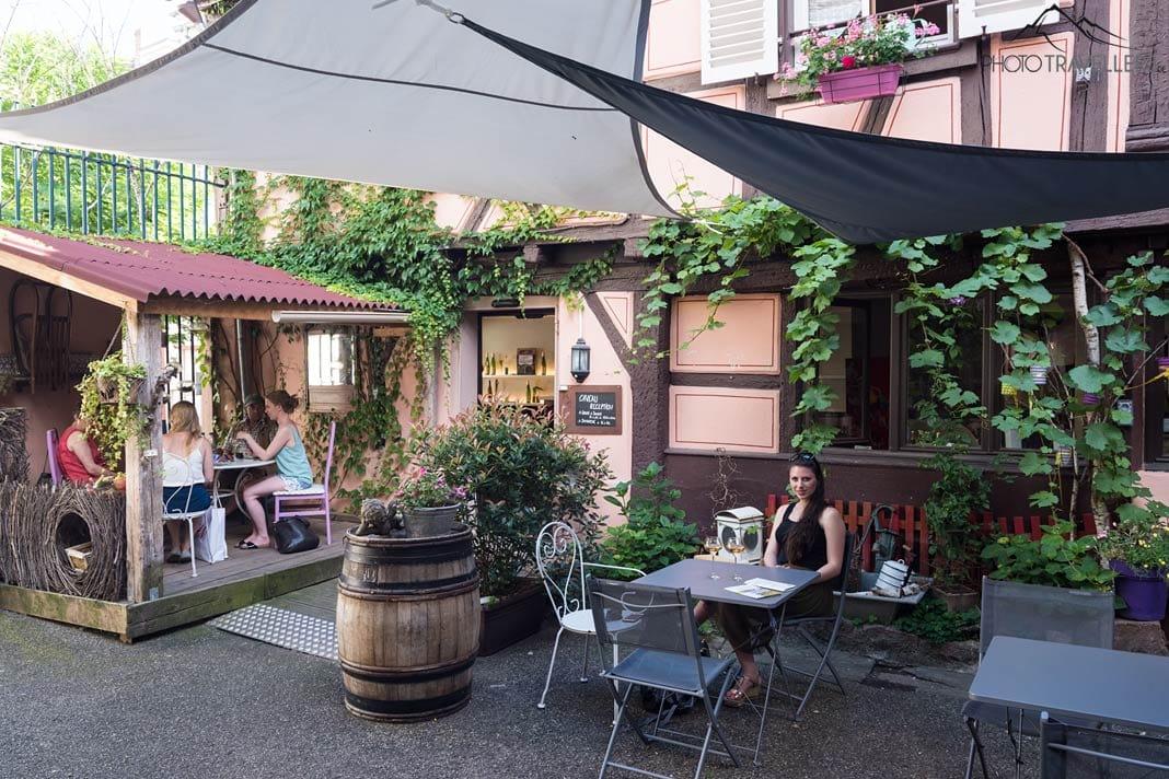 Le blogger de voyage Biggi Bauer assise à une table dans la cour de Maison Martin Jund à Colmar