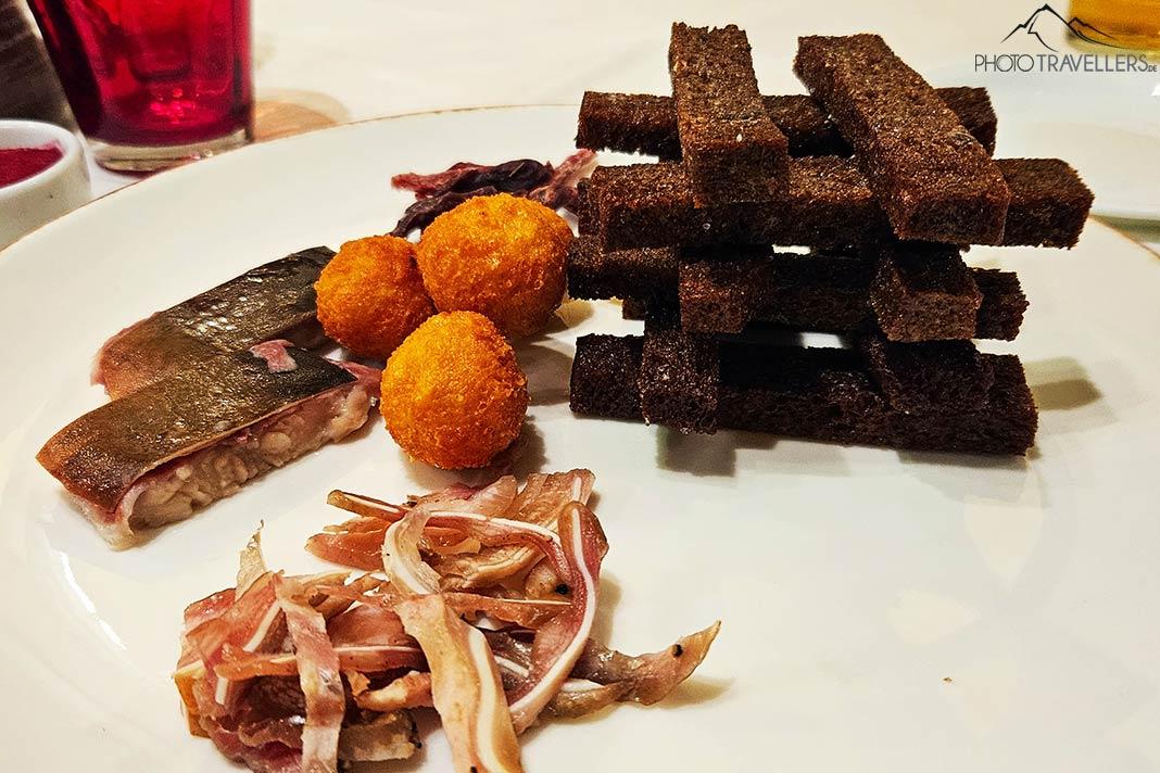 Um prato de aperitivos com orelhas de porco, arenque e pão escuro