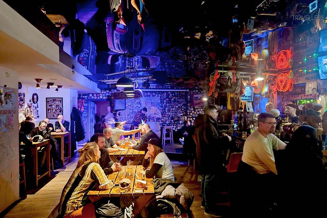 Pessoas conversando em mesas de madeira em um bar