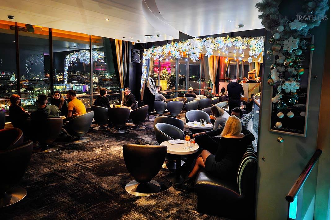 Várias pessoas sentadas nos sofás de um bar