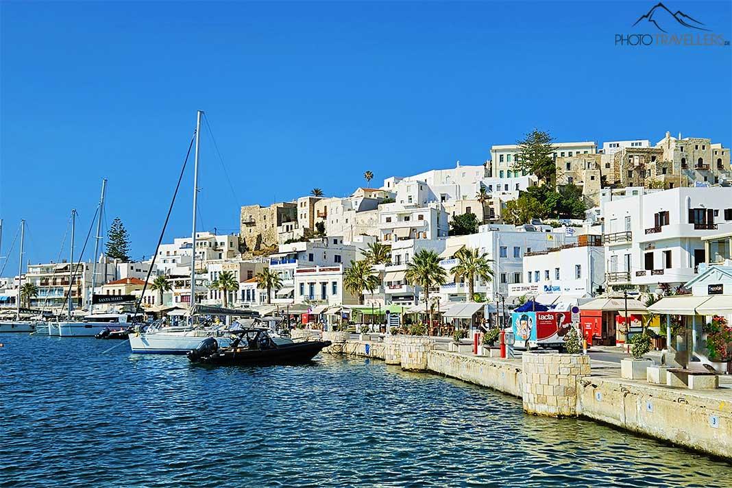 Um pequeno barco ancorado diante da Chora densamente construída de Naxos