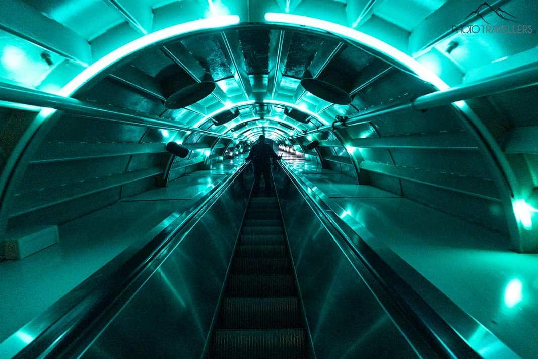 Un long escalator avec un éclairage vert dans l'Atomium à Bruxelles