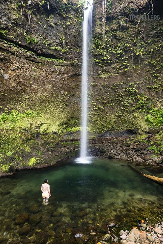 Bloguera de viajes Biggi Bauer en un bikini amarillo en la piscina de las Spanny Falls en Dominica