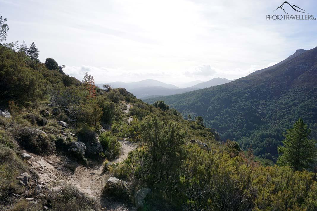 Uma trilha com uma ótima vista, ao longe há montanhas visíveis