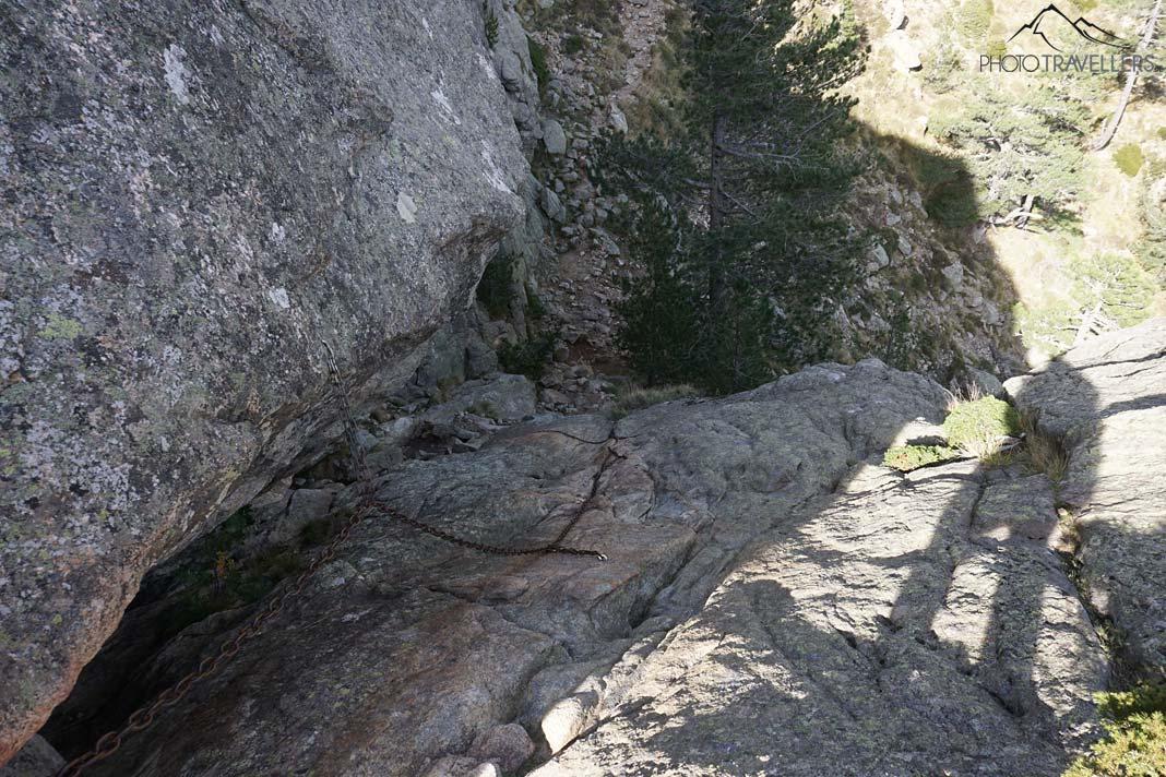 Uma rocha íngreme com uma cadeia de aço, o ponto chave na trilha nas Aiguilles de Bavella