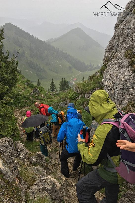 Les participants de la formation de guide de randonnée descendent un sentier rocheux sous la pluie