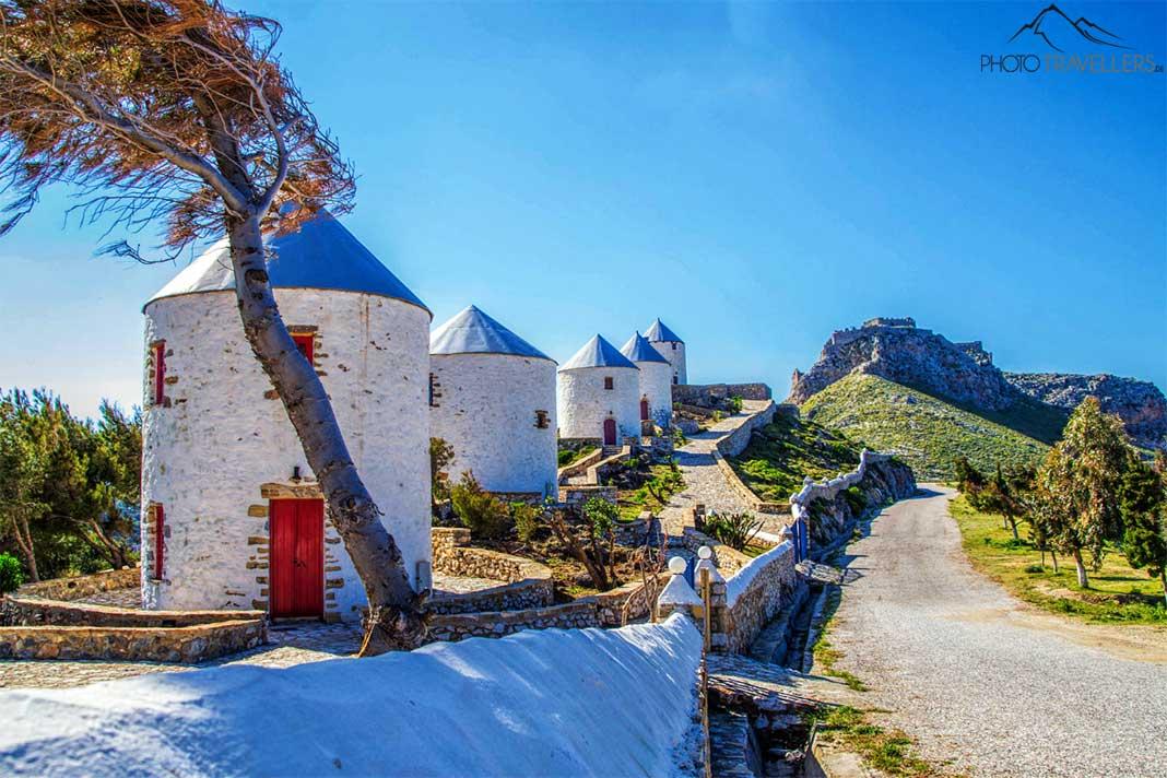 Cinq moulins à vent avec des toits bleus se dressent en ligne