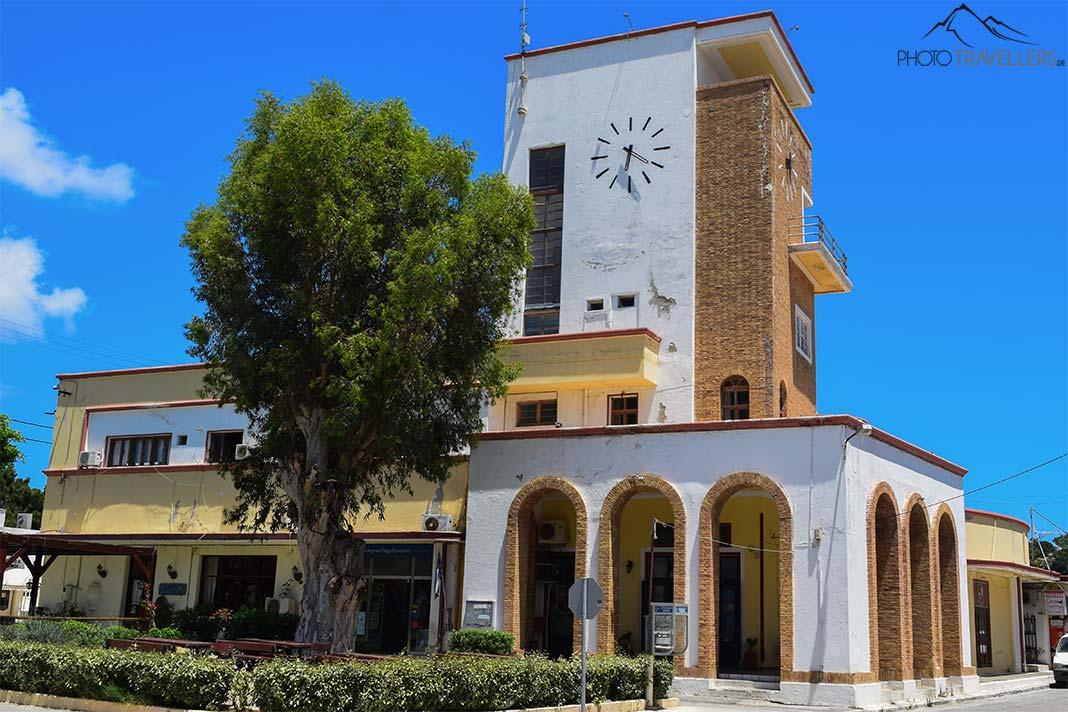 Un bâtiment bas avec des arcs arrondis à côté d'un immeuble témoigne de l'occupation italienne de Lakki
