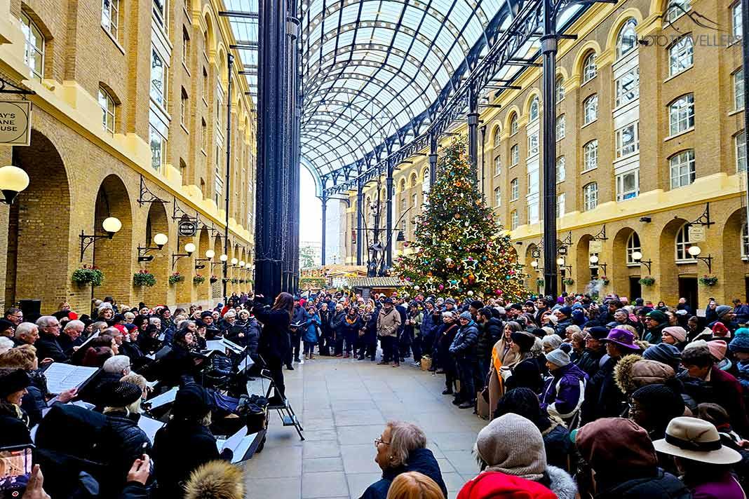 Um grande grupo de pessoas ouve um coral de Natal na Hays Galleria