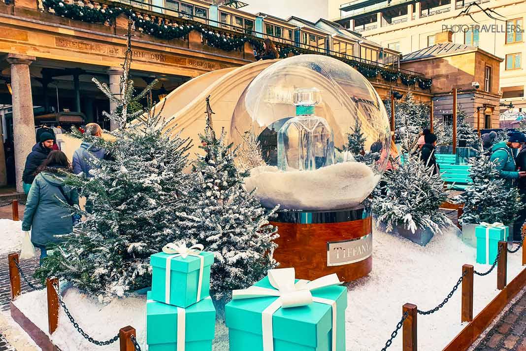 Uma enorme bola de vidro, pacotes de presente e neve artificial criam um clima natalino em Covent Garden