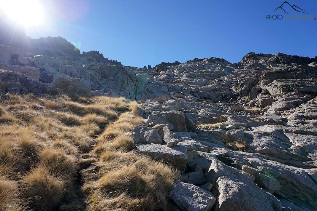 Un chemin étroit dans l'herbe jaune, montant à côté de rochers