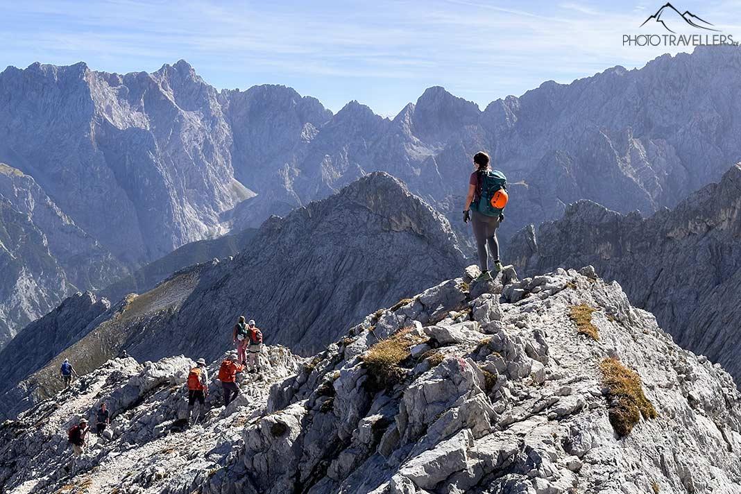 Blogueuse de voyages Biggi Bauer se tenant sur une colline rocheuse sur la crête est de l'Alpspitze, regardant au loin