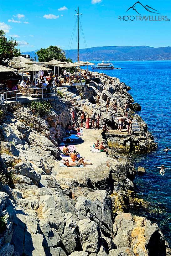Les baigneurs se prélassent sur les rochers de la plage de Spillia