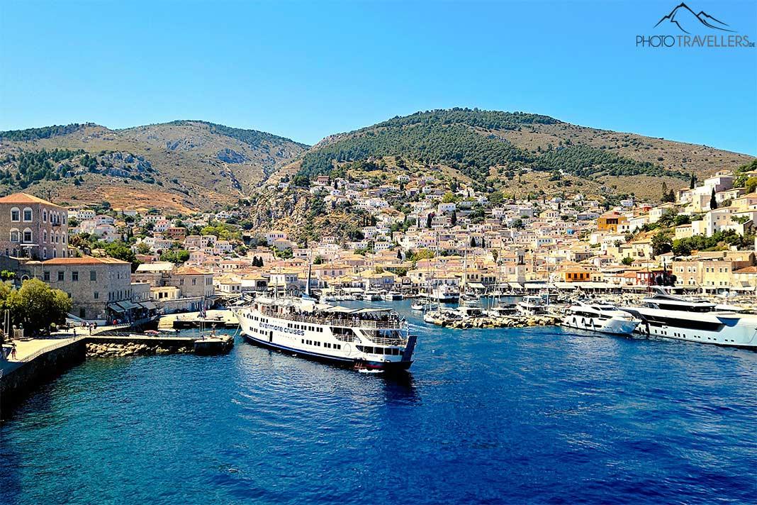Un bateau blanc au port d'Hydra avec les collines construites en arrière-plan