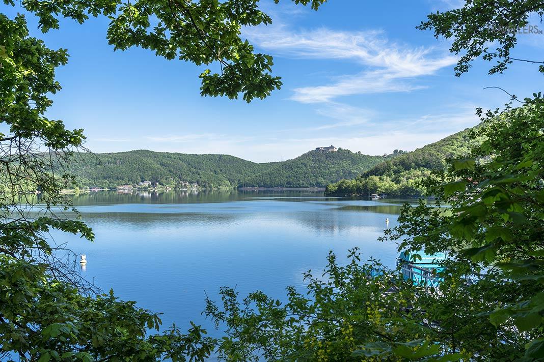 Vue à travers des arbres sur le lac Edersee avec le château de Waldeck