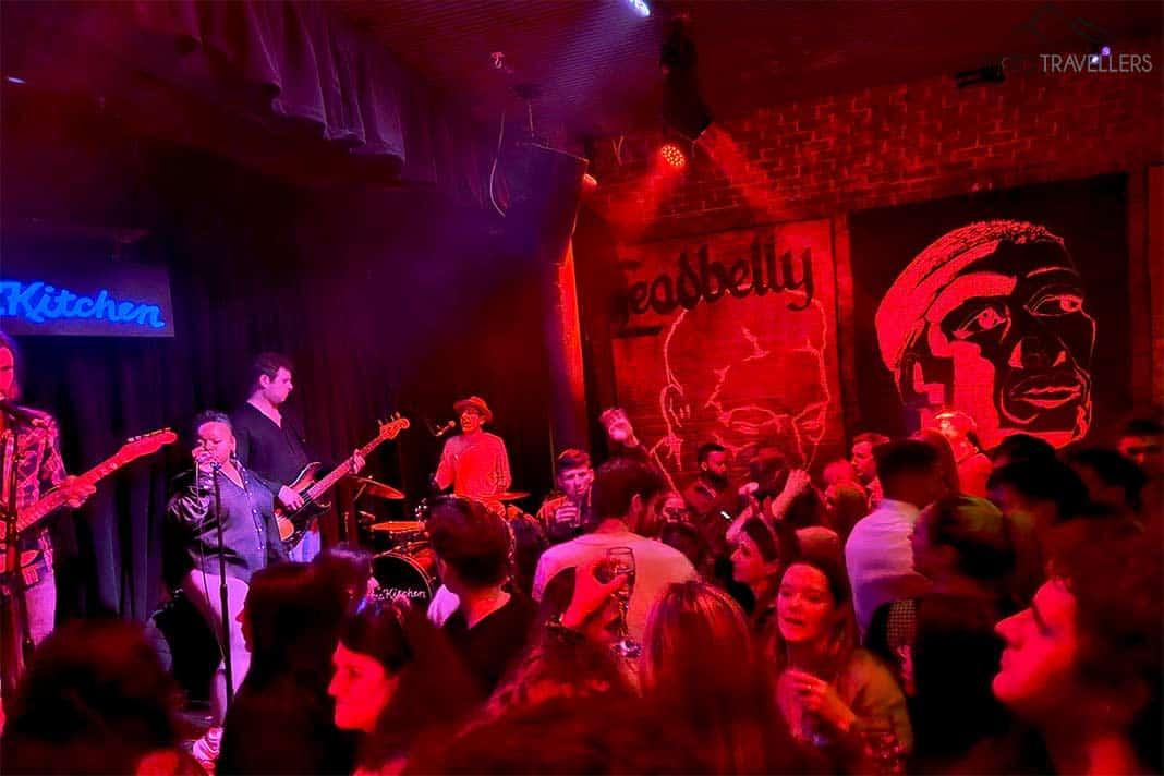 Un groupe joue sur la scène du Blues Kitchen devant de nombreuses personnes dansantes