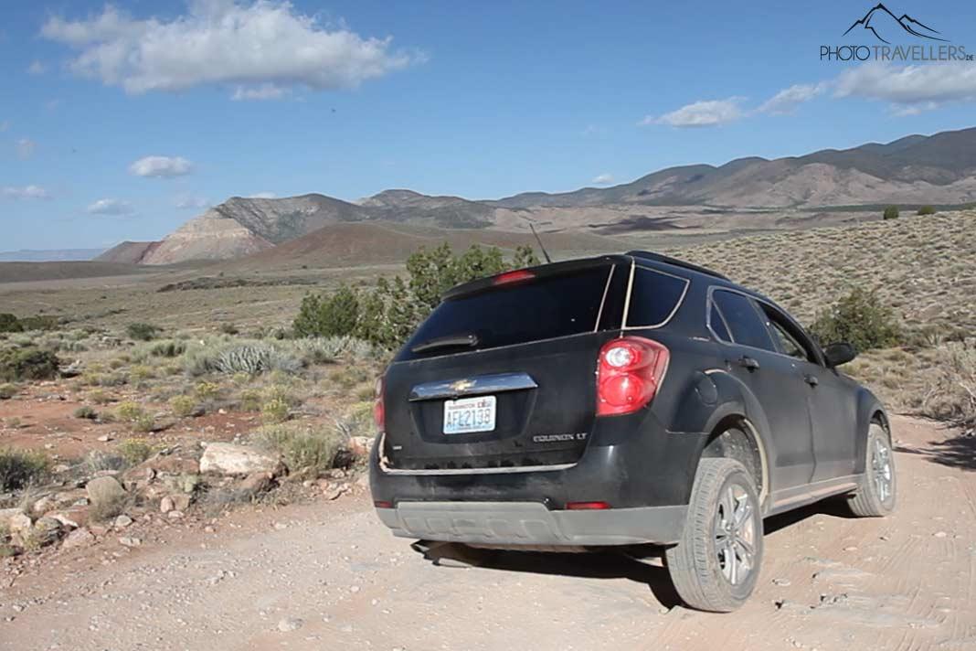 Um SUV preto na estrada de cascalho rumo ao Toroweap Point