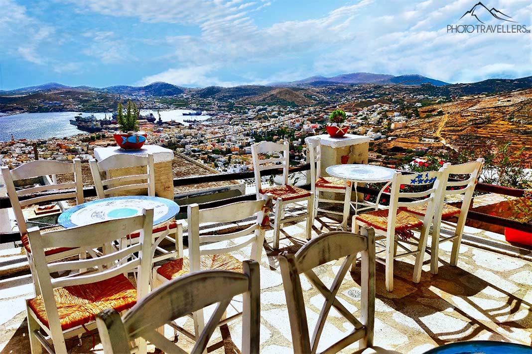 Les tables et chaises sur la véranda d'une taverne à Ano Syros offrent une vue panoramique sur la capitale Ermoupolis