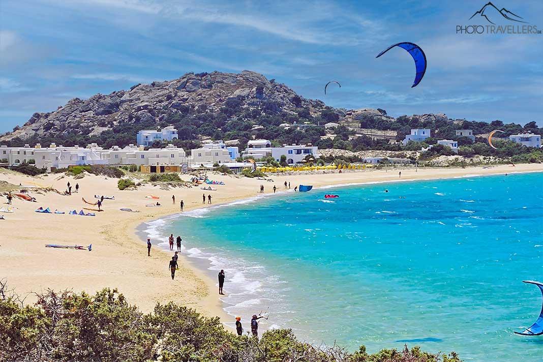 Des gens se promènent sur la plage de sable de Mikri Vigla devant la mer turquoise à Naxos