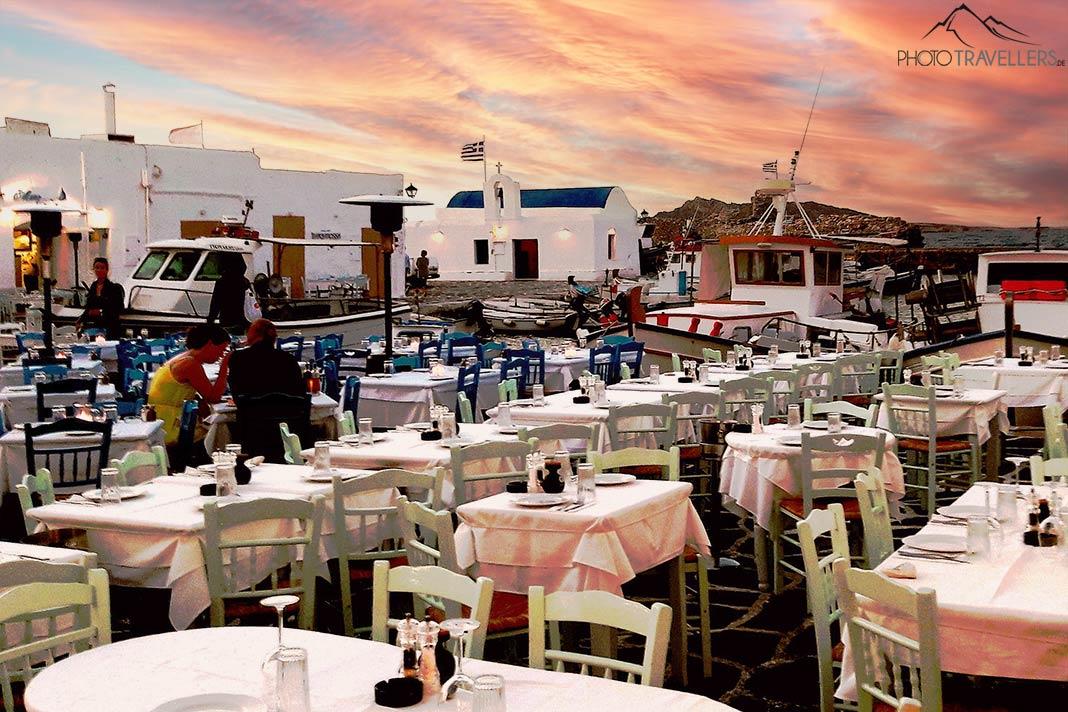 Les rangées de tables au port de Naoussa sur Paros se remplissent lentement au coucher du soleil