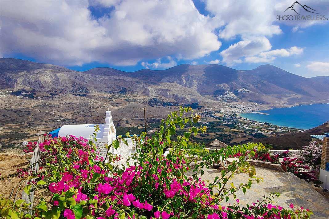 Au-dessus de la baie d'Aegiali se dresse une chapelle blanche et une mer de fleurs roses