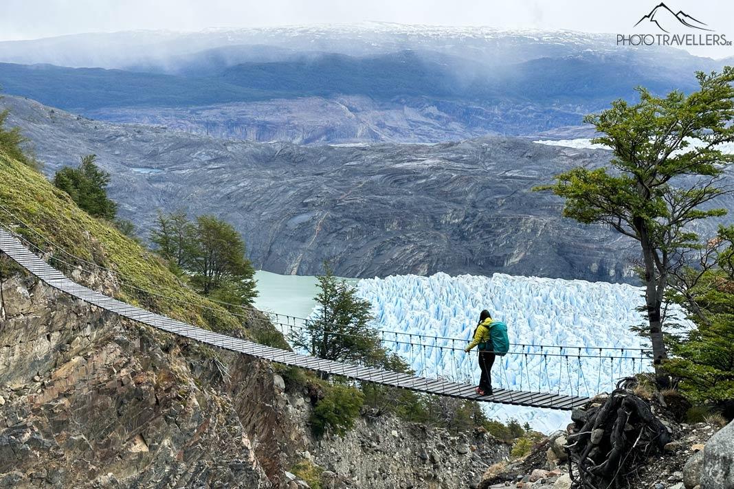 A jornalista de viagem Biggi Bauer na famosa ponte suspensa no Parque Nacional Torres del Paine com o Glaciar Grey ao fundo