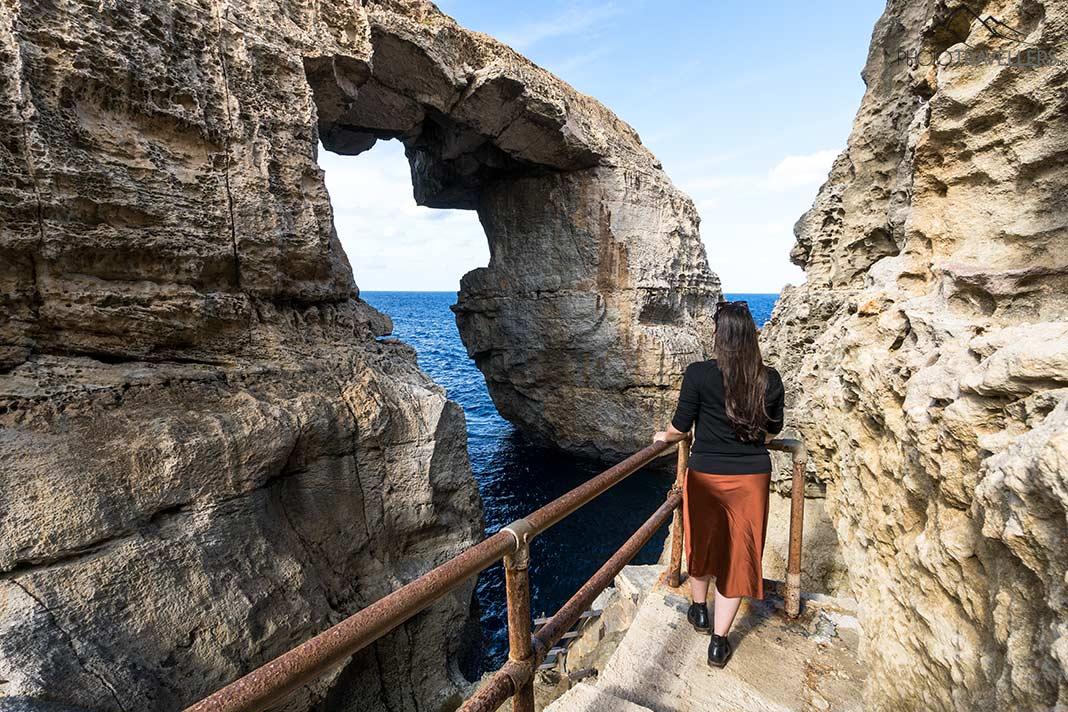 A blogueira de viagens Biggi Bauer em uma pedra na falésia de Wied il-Mielaħ em Gozo