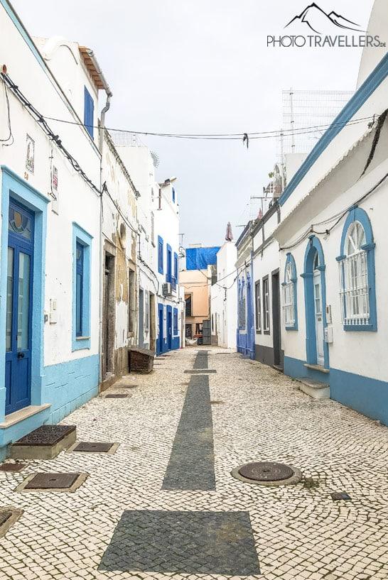 Vista de un callejón con casas de pescadores blancas y azules en Olhão