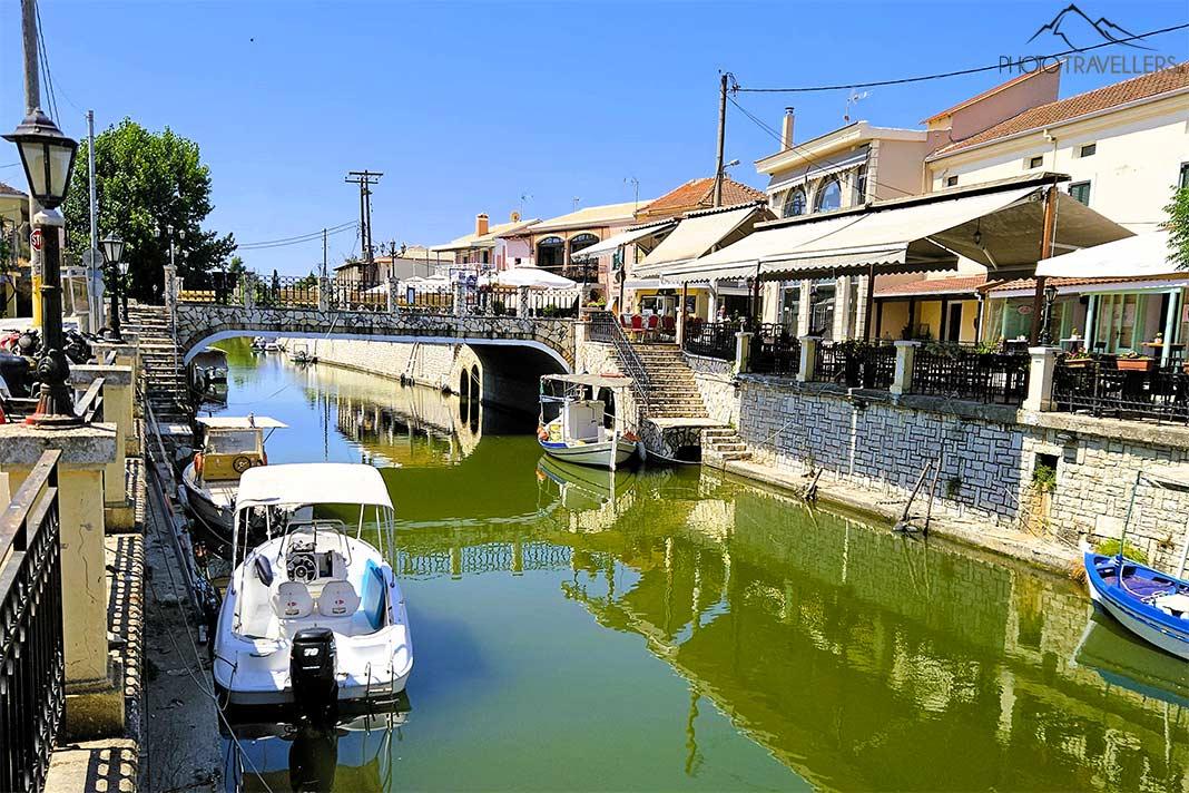 Barcos y locales bordean la orilla del canal verde brillante en Lefkimmi