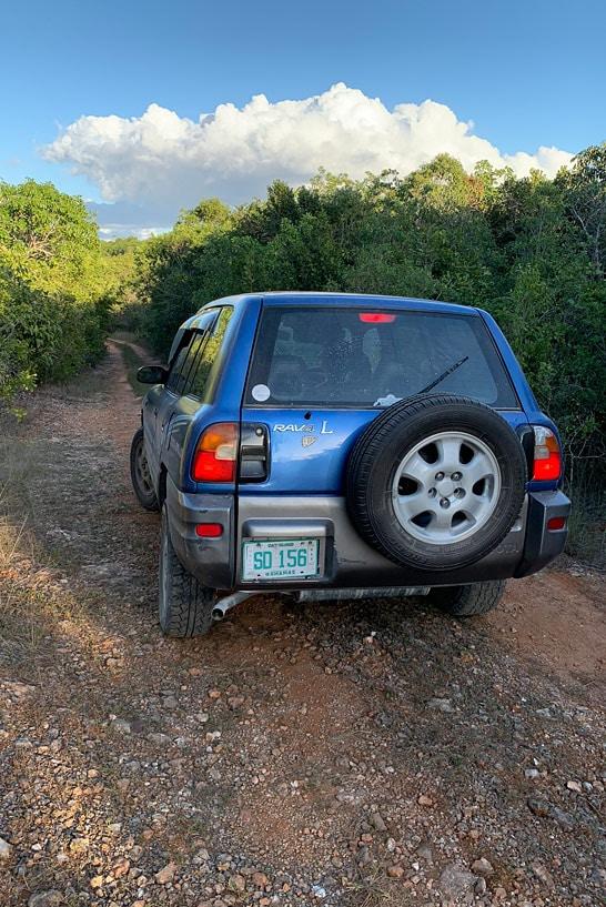 Um Toyota RAV 4 azul em uma estrada de terra na Cat Island